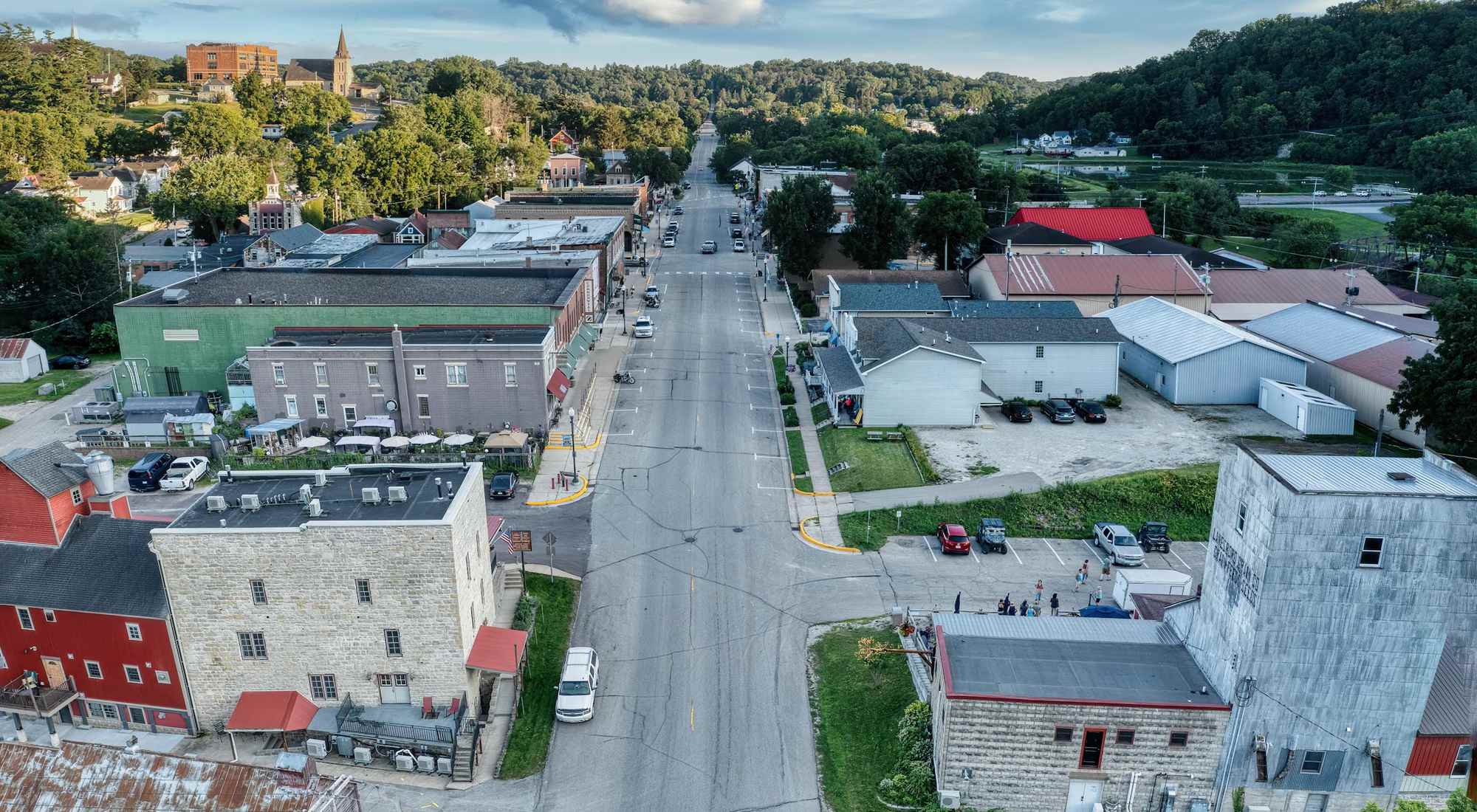 An aerial view of a small Midwestern town surrounded by green fields and tree-lined streets