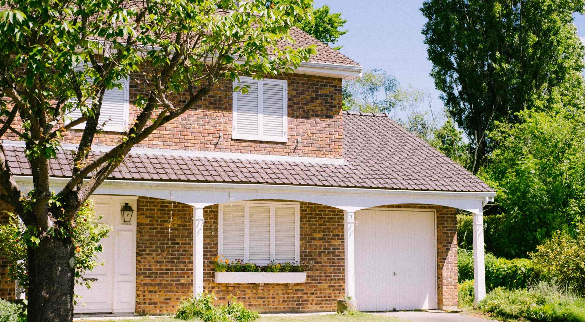 A welcoming two-story brick home with a green front lawn on a sunny day in southern Illinois